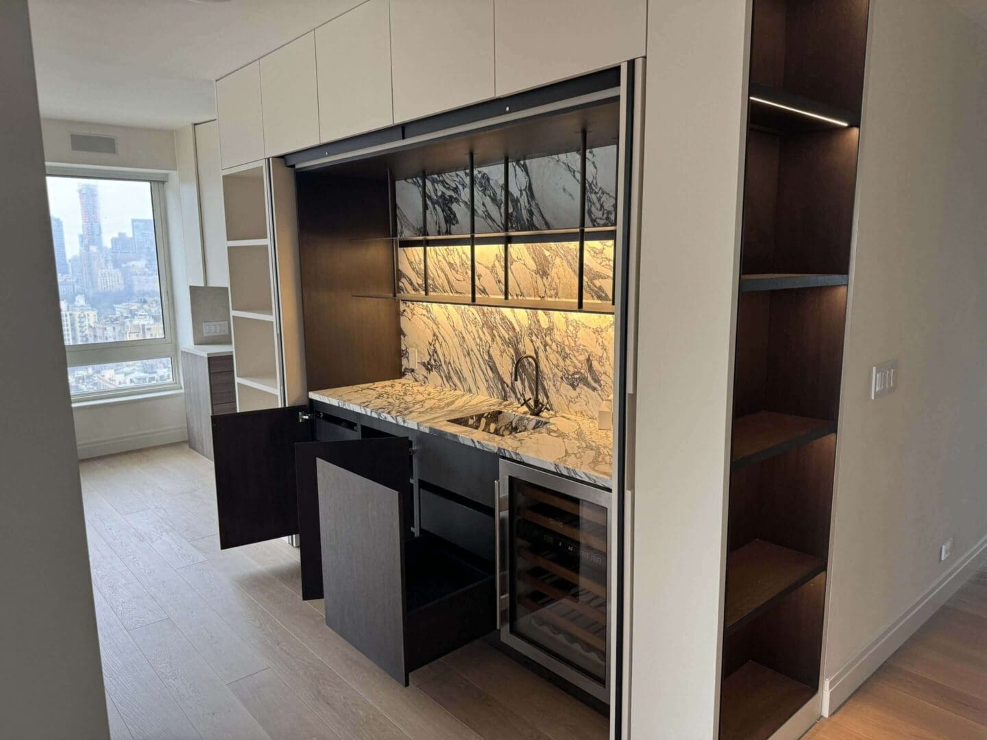 Modern kitchen with marble backsplash and open cabinets.