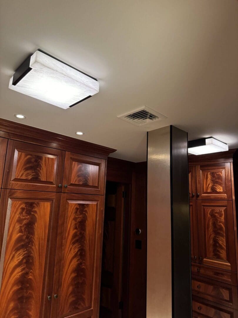 Elegant wooden-paneled room with modern ceiling lights and a metal column.