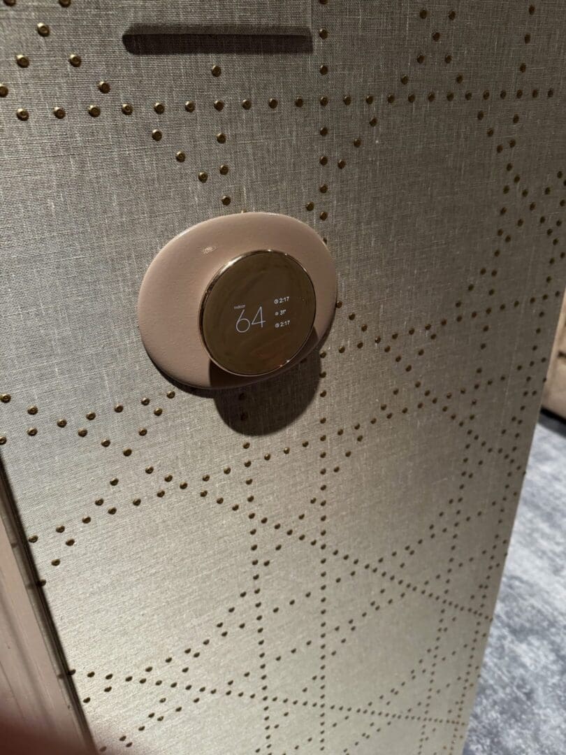 A close-up of a round, beige-colored door handle on a patterned door.
