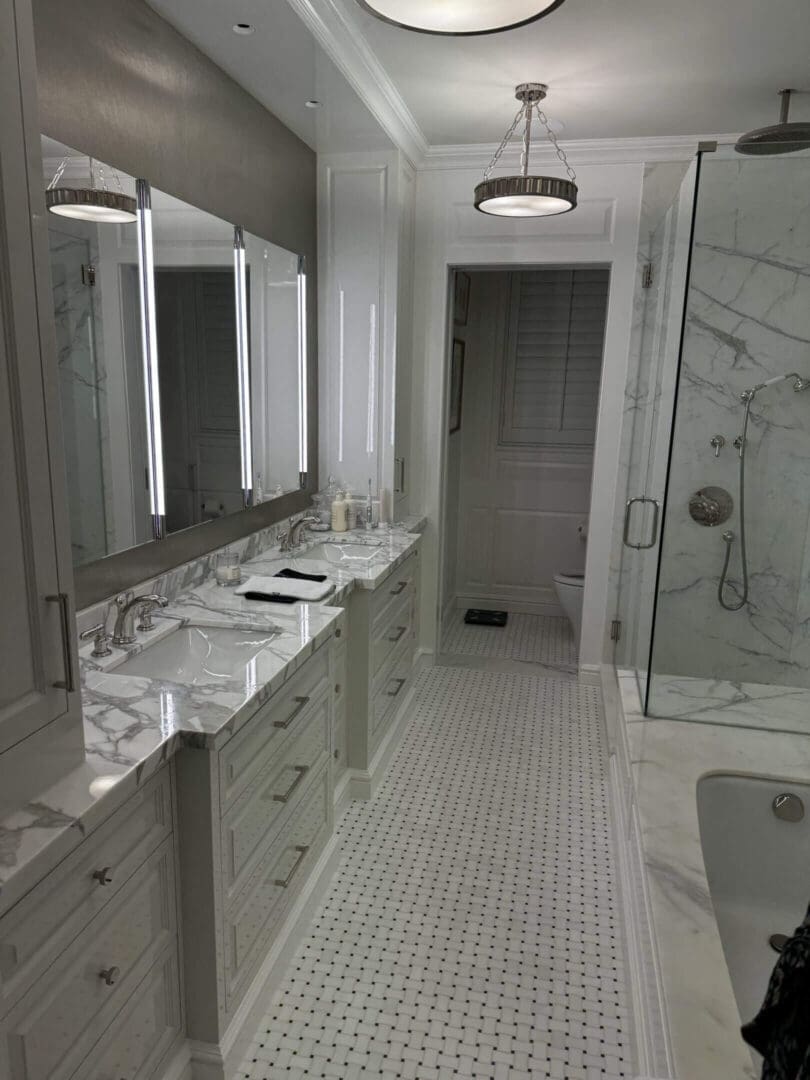 Elegant bathroom with marble countertops and glass shower.