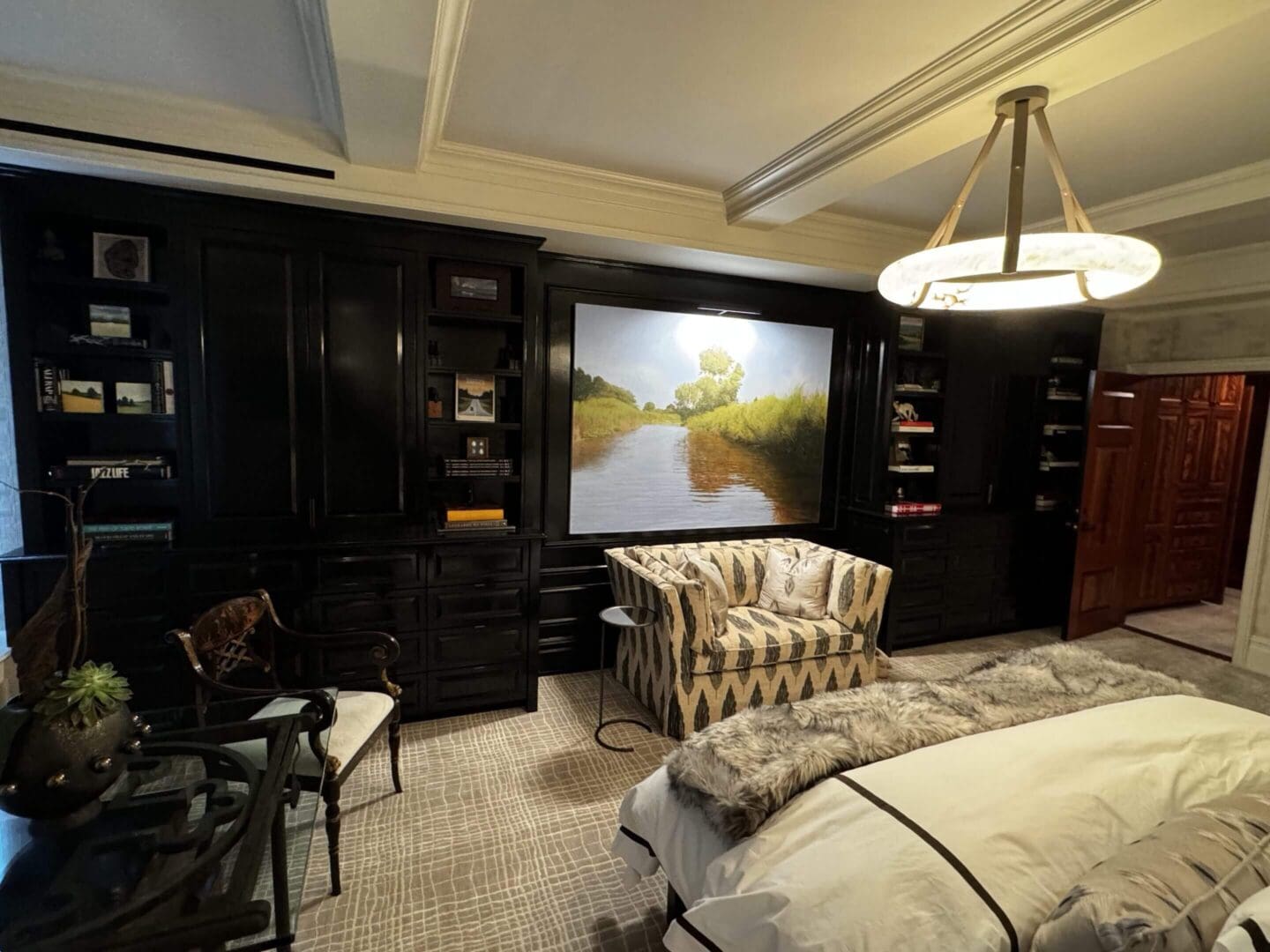 Luxurious bedroom with dark wood furniture and a scenic landscape painting.