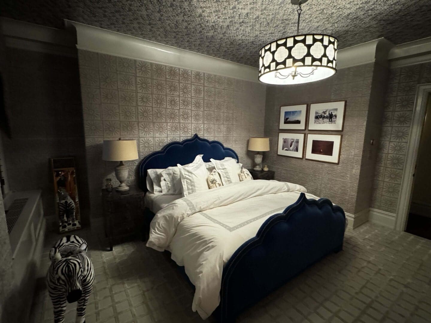 Luxurious bedroom with a plush navy bed and elegant lighting.