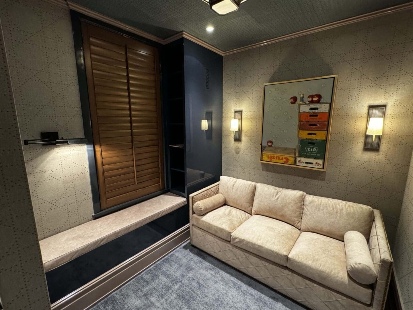 Cozy living room with beige sofa and wooden window shutters.