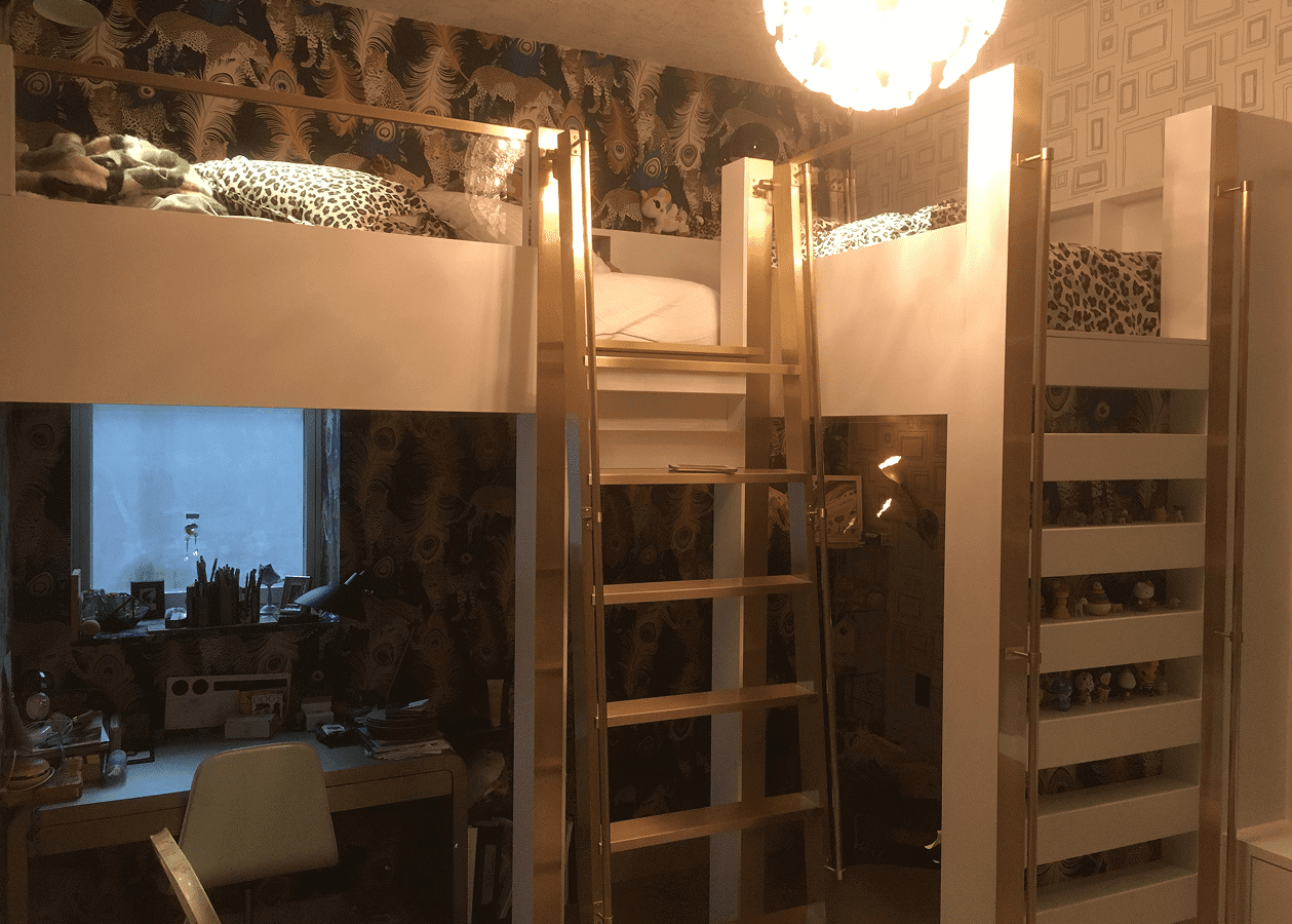 Wooden bunk bed with a ladder in a cozy room.