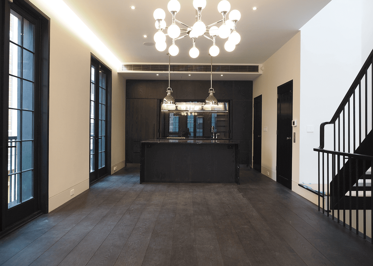Modern kitchen with dark cabinetry and pendant lighting.