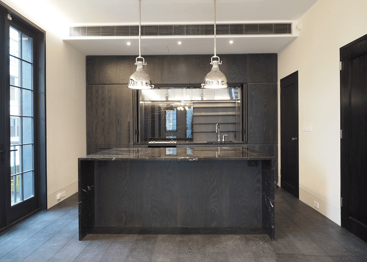 Modern kitchen with dark cabinetry and pendant lighting over island.