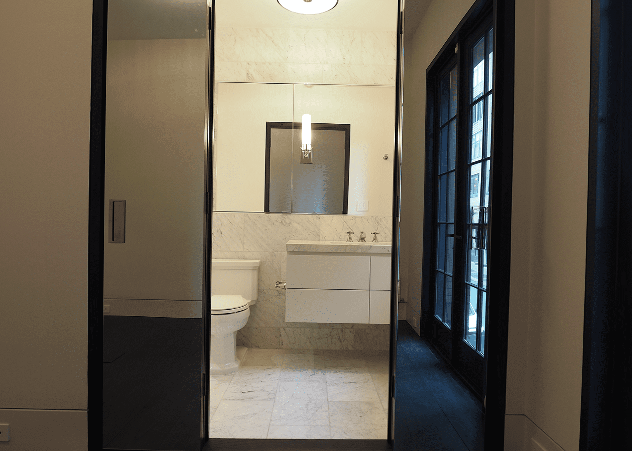 Modern bathroom with white vanity and large mirror.