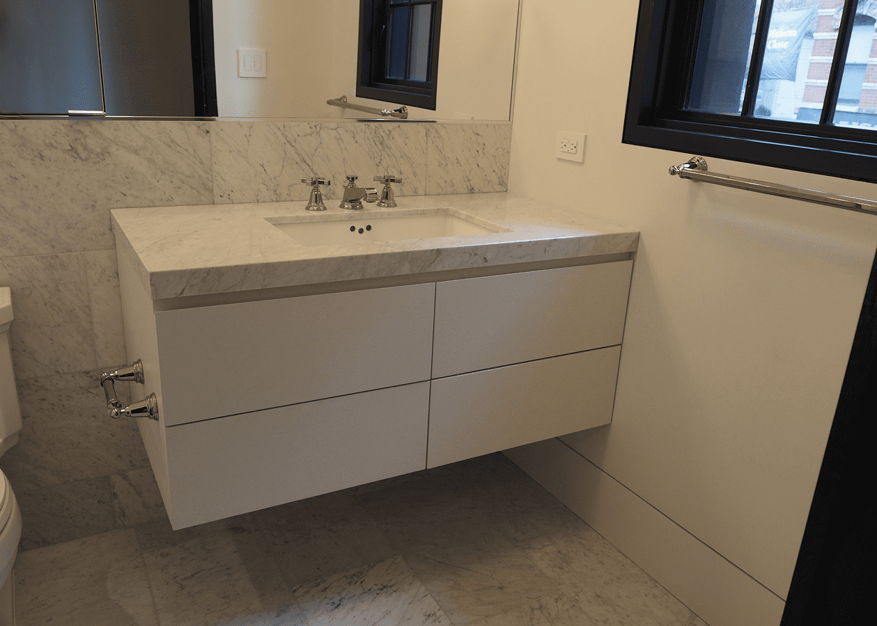 Modern floating bathroom vanity with white drawers and a marble countertop.