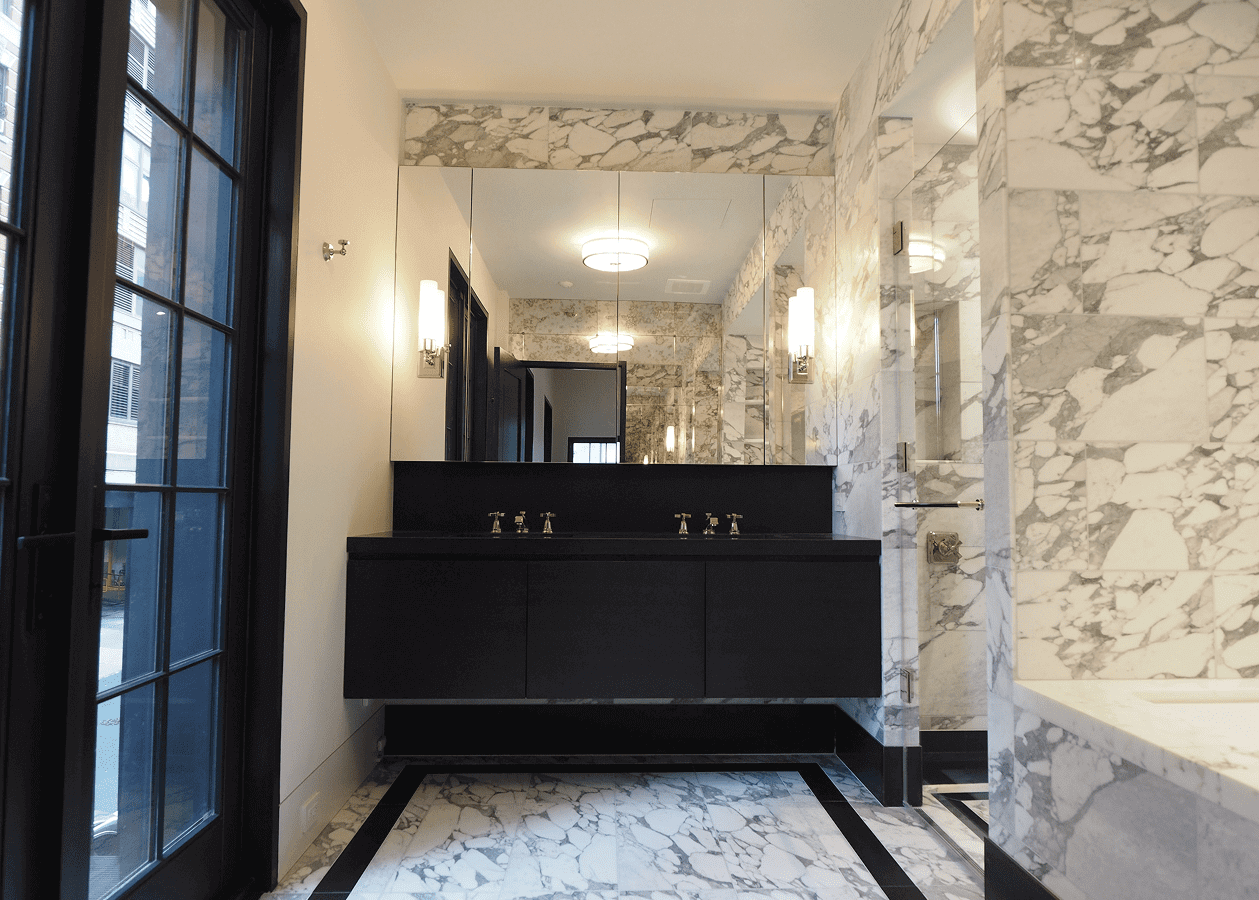 Elegant bathroom with marble walls and black vanity.