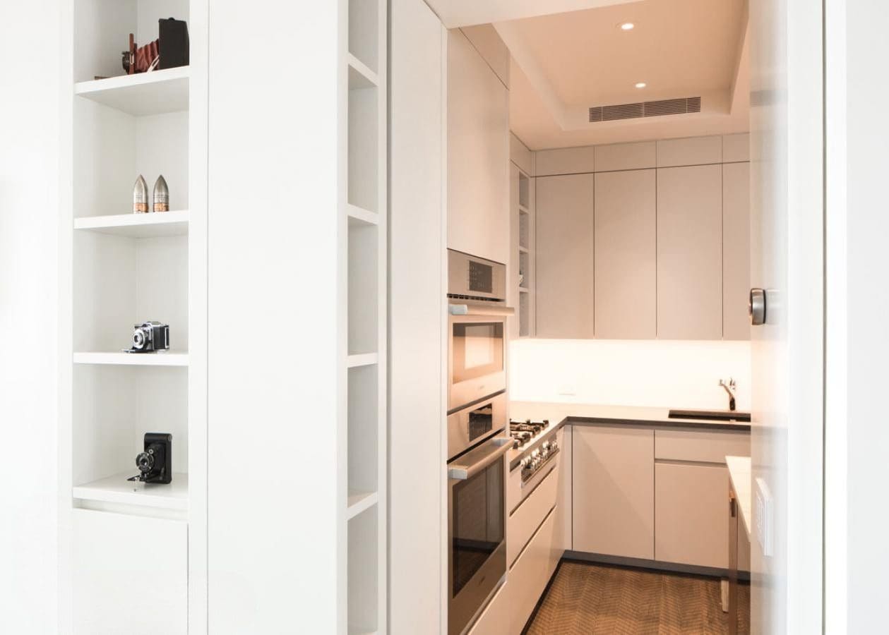 Modern kitchen with white cabinets and built-in appliances.