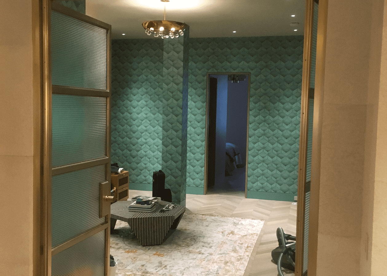 Modern living room with teal textured walls and elegant decor.