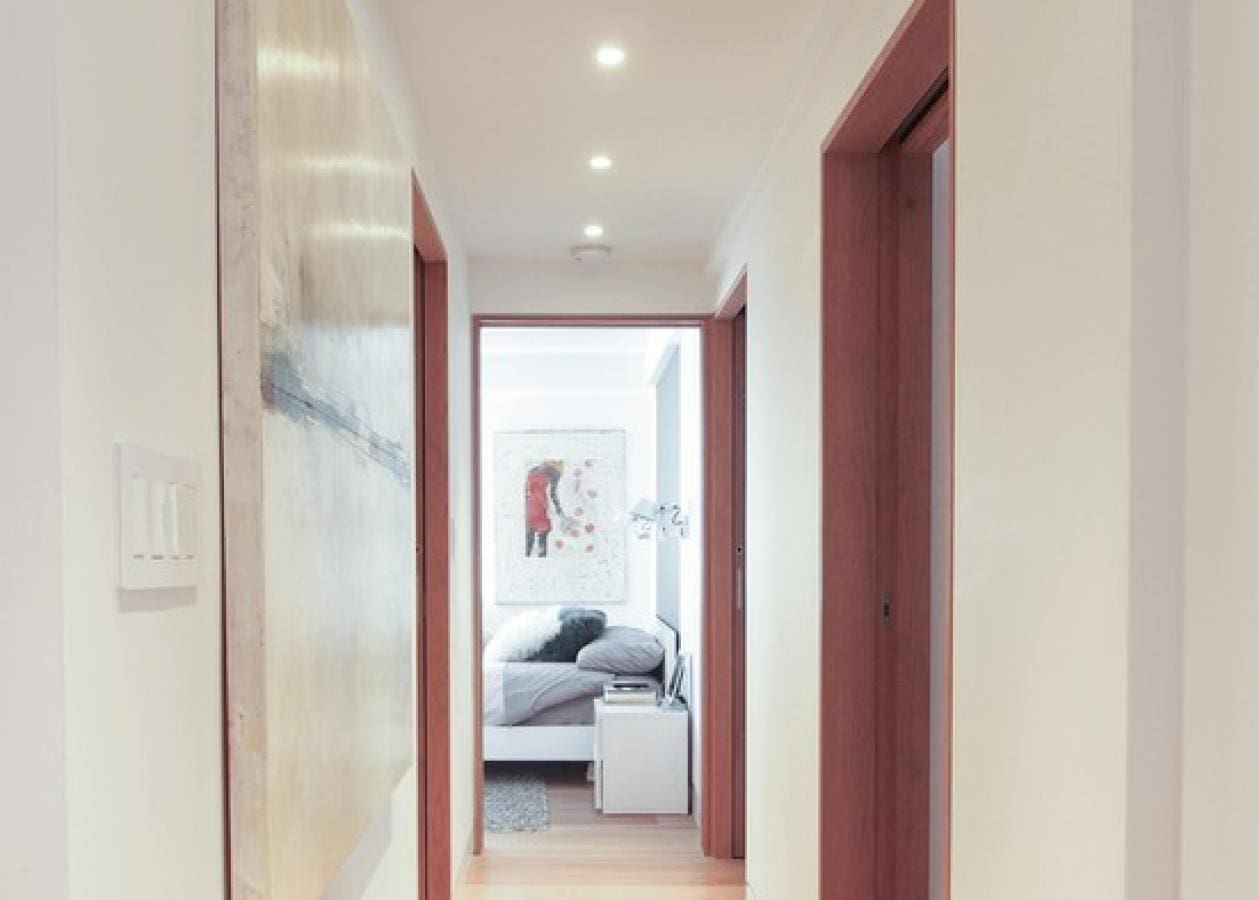 Bright hallway leading to a cozy bedroom with modern decor.