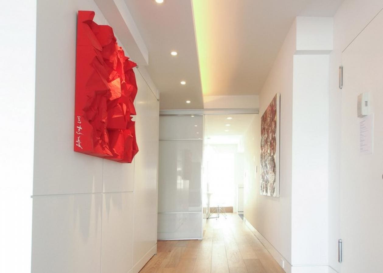 Modern hallway with bright red abstract wall art and natural light.