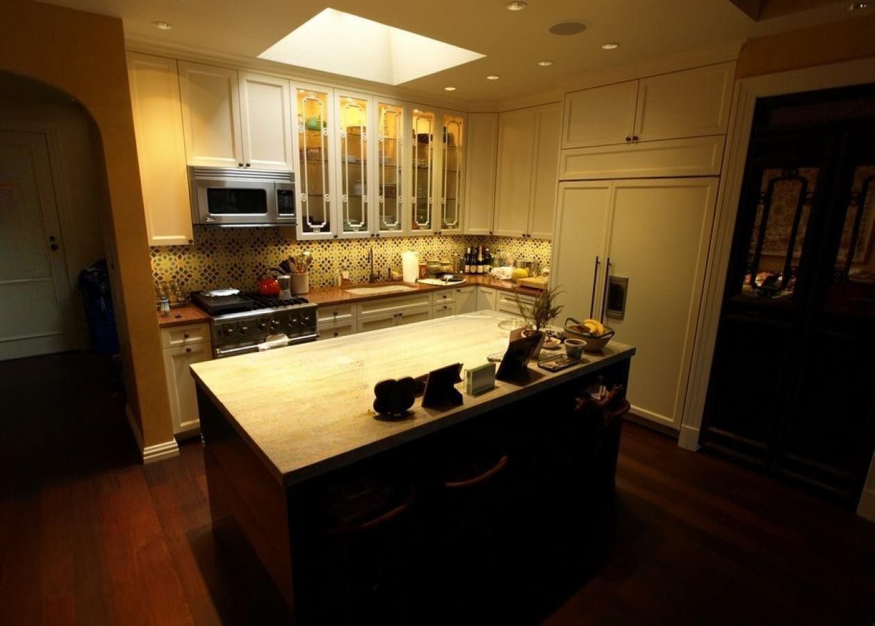 Cozy kitchen with warm lighting and a marble island countertop.