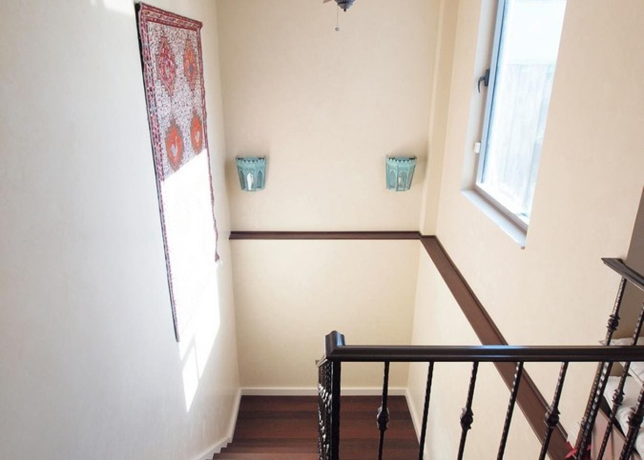 Bright stairway with decorative blue wall planters and a patterned curtain.