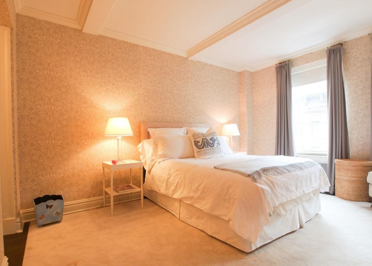 Cozy bedroom with soft lighting and plush bedding.