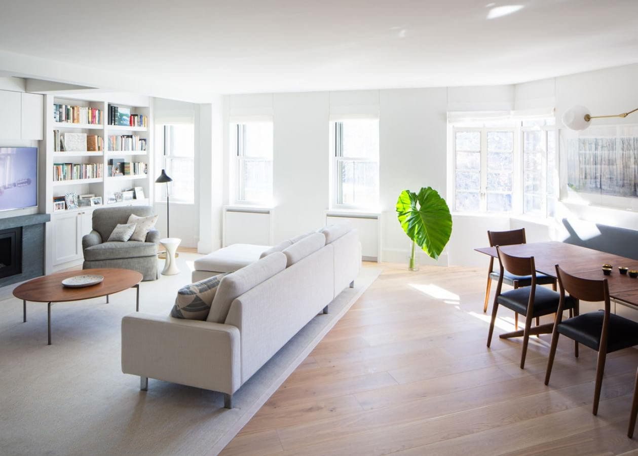Bright modern living room with white walls and large windows.
