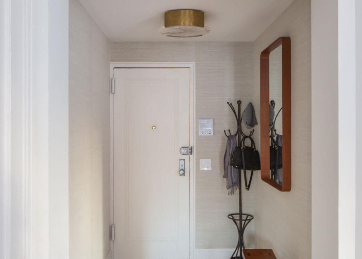 Minimalist hallway with white door and coat rack.