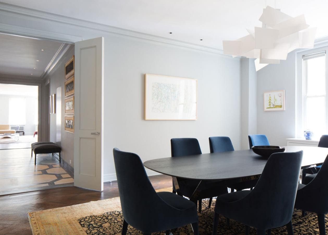 Modern dining room with black chairs and a round table.
