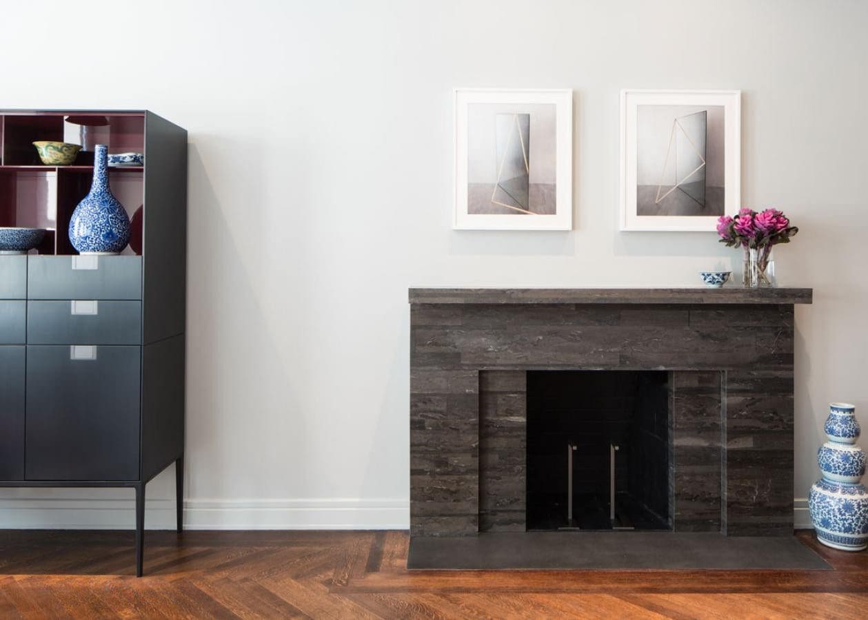 Minimalist living room with a rustic fireplace and modern cabinet.