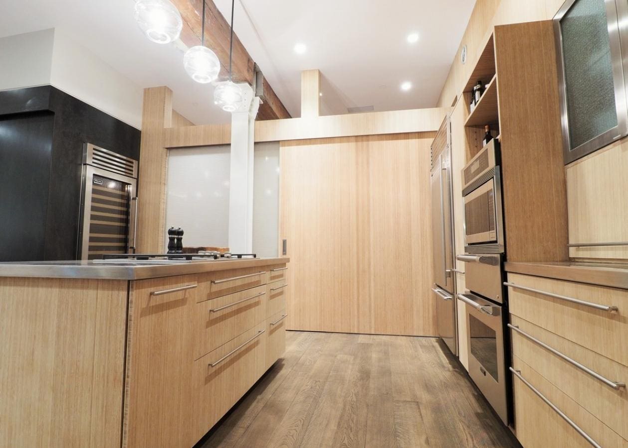 Modern kitchen with wooden cabinets and sliding doors.